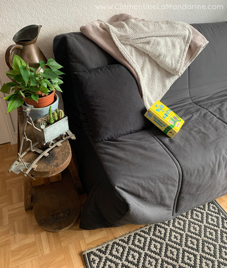 Astuces pour chauffer moins sans travaux et en gardant son confort : un plaid sur le canapé, un tapis au sol.