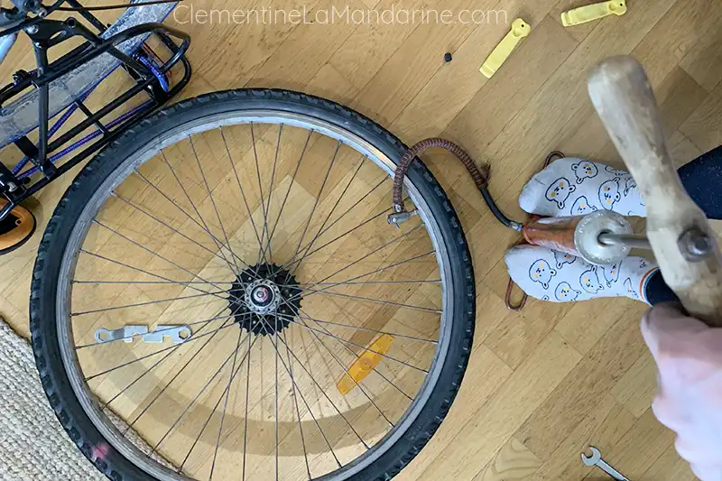 Une personne regonfle un pneu de vélo fraichement réparé.